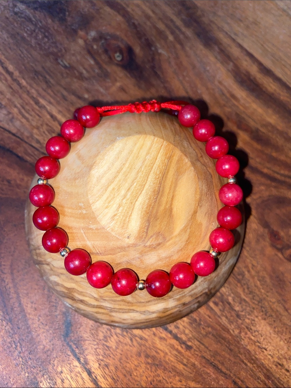 8 mm coral red & 14 k gold spacers adjustable bracelet.